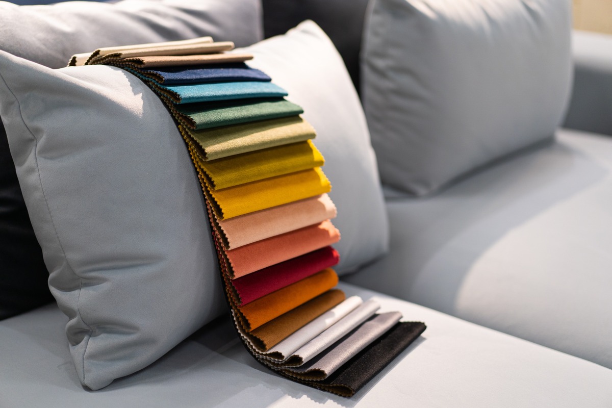 telas de tapizado de colores sobre cojin de sofa gris